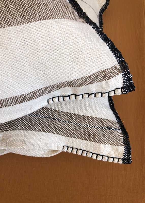 The hand stitched corners of two unique handwoven cushions